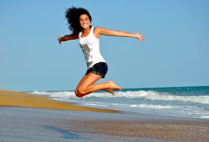 jumping woman in front of sea